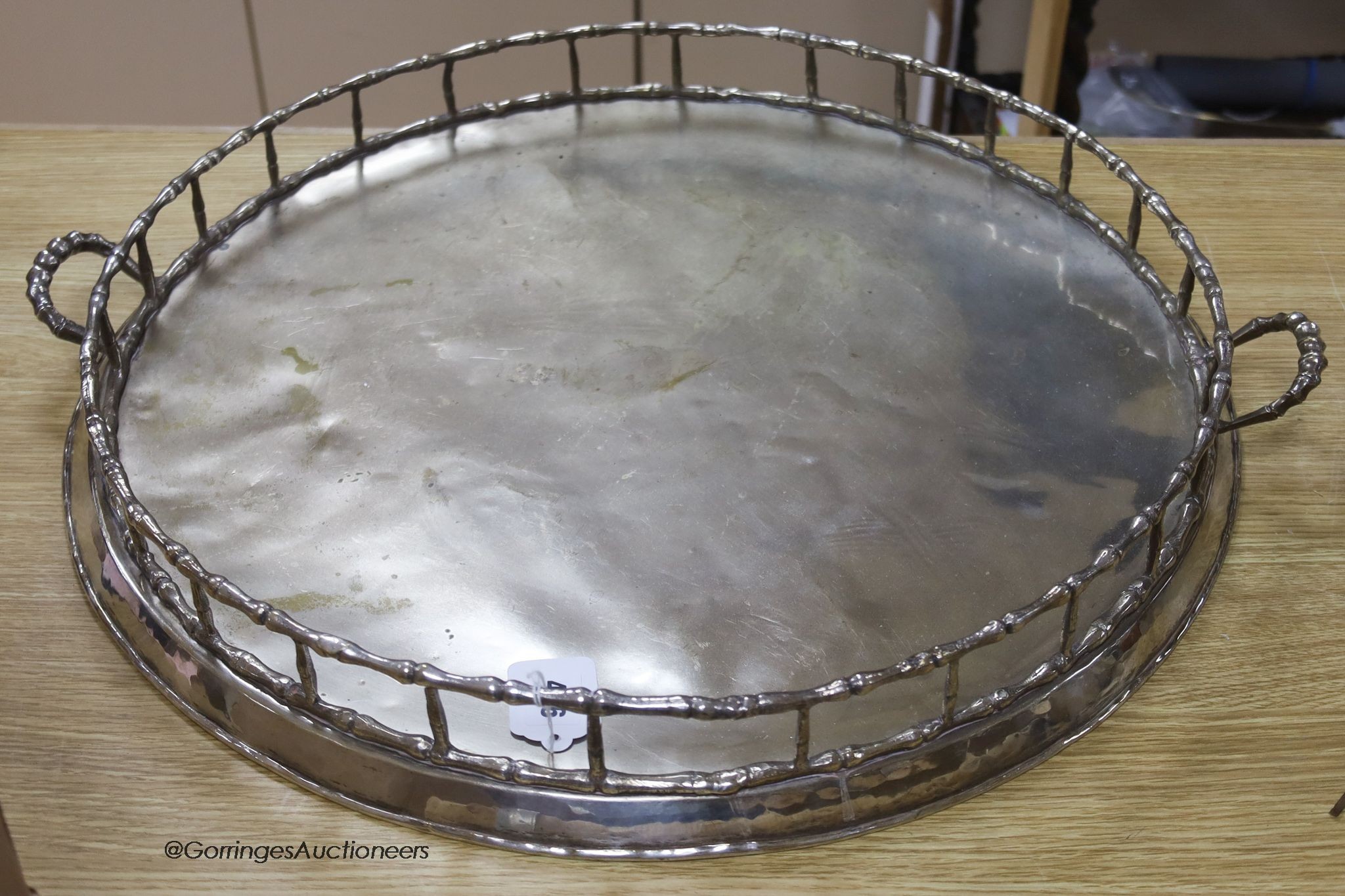 A large Iranian plated two-handled circular tray, 64cm handle to handle